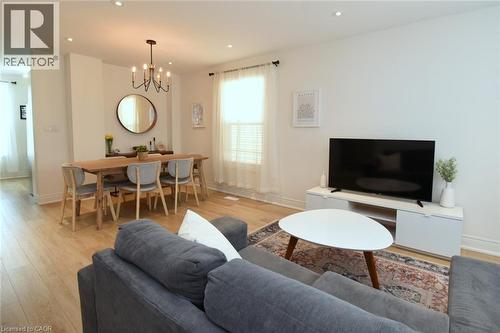 Open-concept living and dining area featuring wood-finish flooring, recessed lighting, and a chandelier - 106 Belview Avenue, Hamilton, ON - Indoor Photo Showing Living Room