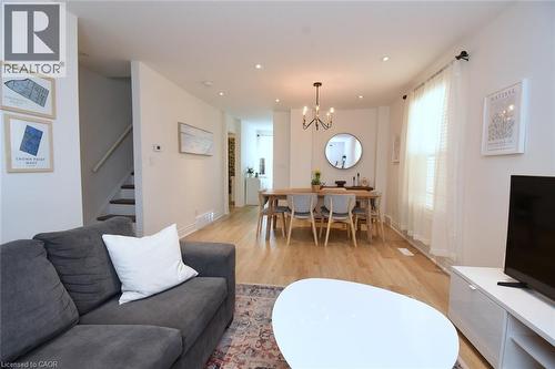Open-concept living and dining area featuring light wood-finish flooring, recessed lighting, and a modern chandelier - 106 Belview Avenue, Hamilton, ON - Indoor Photo Showing Living Room