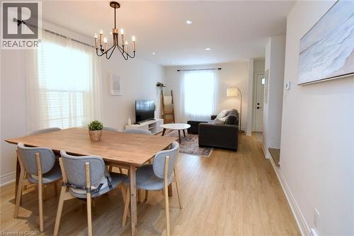 Open-concept living area with wood-finish flooring, recessed lighting, and a modern chandelier - 106 Belview Avenue, Hamilton, ON - Indoor Photo Showing Dining Room