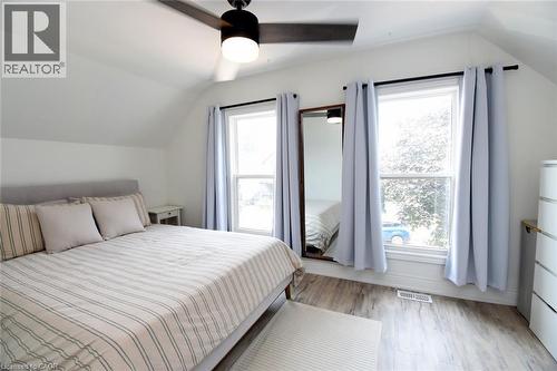Bright room featuring wood-finish flooring, a contemporary ceiling fan, and multiple windows - 106 Belview Avenue, Hamilton, ON - Indoor Photo Showing Bedroom