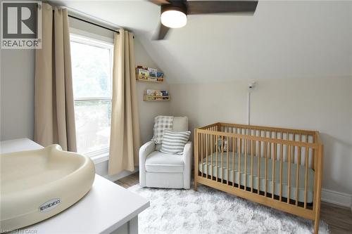 Angled ceiling room with a window, wood-finish flooring, and a ceiling fan with integrated lighting - 106 Belview Avenue, Hamilton, ON - Indoor Photo Showing Bedroom
