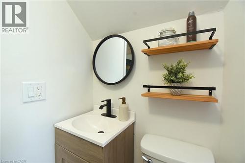 Modern vanity with a white countertop and integrated sink, matte black faucet, and wood-finish cabinetry - 106 Belview Avenue, Hamilton, ON - Indoor Photo Showing Bathroom
