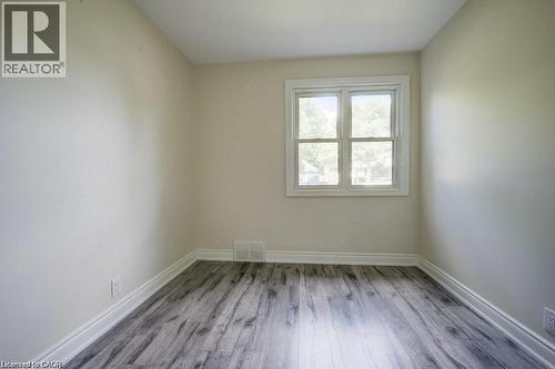Room featuring wood-finish flooring, light-toned walls, and a white-framed window - 33 Sixth Avenue Unit# Upper, Kitchener, ON - Indoor Photo Showing Other Room