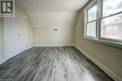 Room featuring wood-finish flooring, white baseboards, and a neutral wall color - 
