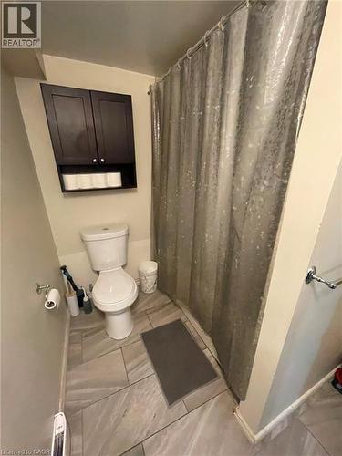 Bathroom featuring a built-in shower area, a white toilet, and dark wood-finish wall cabinetry - 267 Mackie Place Unit# 2, Kitchener, ON - Indoor Photo Showing Bathroom