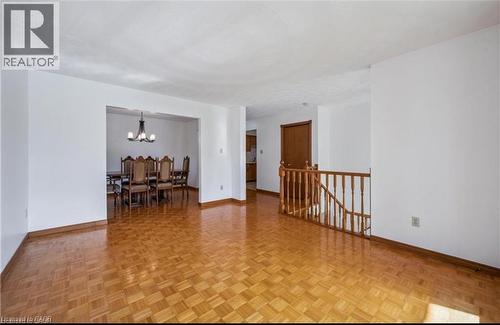 Bright interior space featuring parquet wood flooring and white walls - 42 Azores Crescent, Cambridge, ON - Indoor Photo Showing Other Room