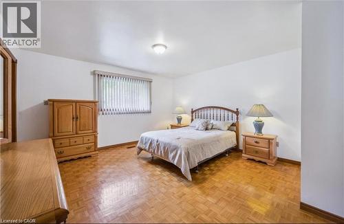 Spacious room featuring parquet wood flooring, white walls, and a window with horizontal blinds - 42 Azores Crescent, Cambridge, ON - Indoor Photo Showing Bedroom