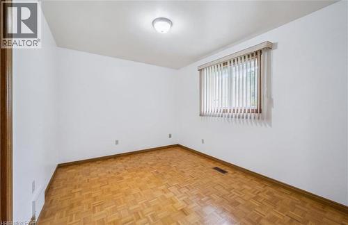 Room featuring wood-finish parquet flooring, white painted walls, and a window with vertical blinds - 42 Azores Crescent, Cambridge, ON - Indoor Photo Showing Other Room