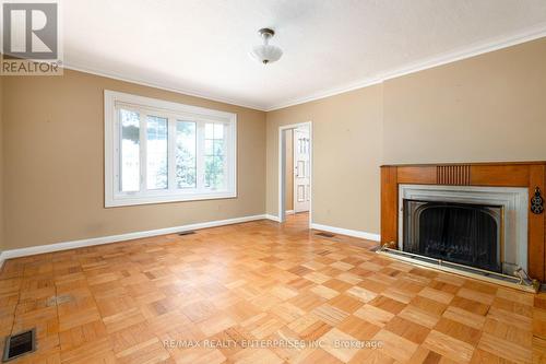 Main floor living room with wood burning fireplace - 52 Briarwood Avenue, Mississauga, ON - Indoor With Fireplace