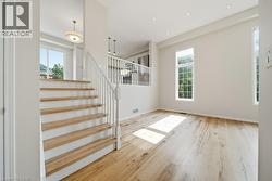 Hardwood flooring throughout the main level featuring a white spindle staircase with wood treads - 