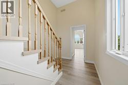Staircase featuring light wood balusters and handrail with white risers - 