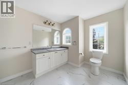 Bathroom featuring white cabinetry, a single basin sink, and a gray countertop - 