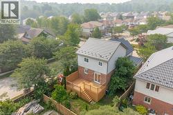 Rear exterior featuring a multi-level wood deck with railings, sliding glass door access, and a fenced yard - 