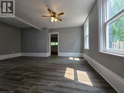 Spacious interior room featuring wood-finish flooring, neutral gray wall tones, and white trim - 