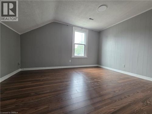Room featuring wood-finish flooring, paneled walls, a double-hung window, and a ceiling-mounted light fixture - 109 Sydenham Street, Brantford, ON - Indoor Photo Showing Other Room