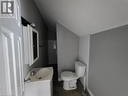 Bathroom featuring a white vanity with integrated sink, chrome faucet, and mirrored medicine cabinet - 