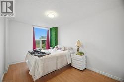 Room featuring wood-finish flooring, white painted walls, and a window offering natural light - 