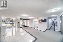 Building lobby featuring polished tile flooring, recessed and flush-mount lighting, and automatic entry doors - 