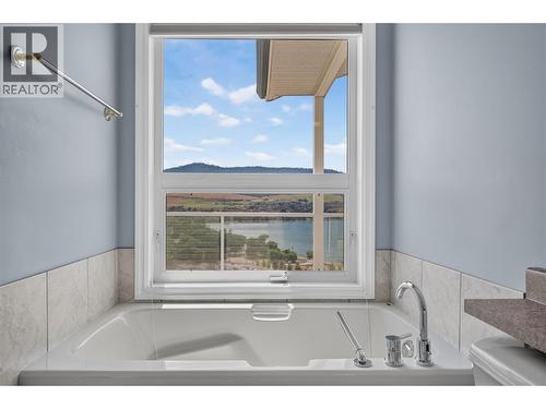 Lake views from the bathtub. - 7083 Jasper Drive, Vernon, BC - Indoor Photo Showing Bathroom