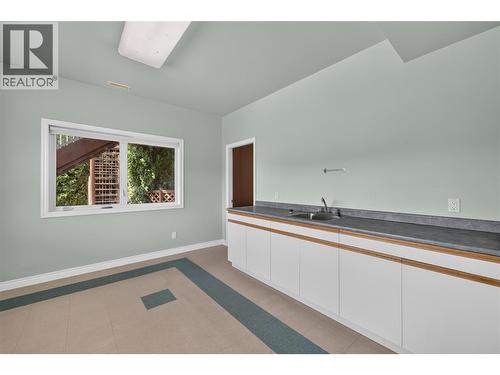 Lower level bar/bonus room with endless possibilities. Perfect as a speakeasy, art studio, hobby room, fitness space, or entertaining lounge. - 7083 Jasper Drive, Vernon, BC - Indoor