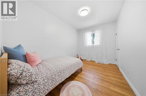 Bright room featuring wood-finish flooring, a window, and a ceiling-mounted light fixture - 80 Jackson Avenue, Kitchener, ON - Indoor Photo Showing Bedroom
