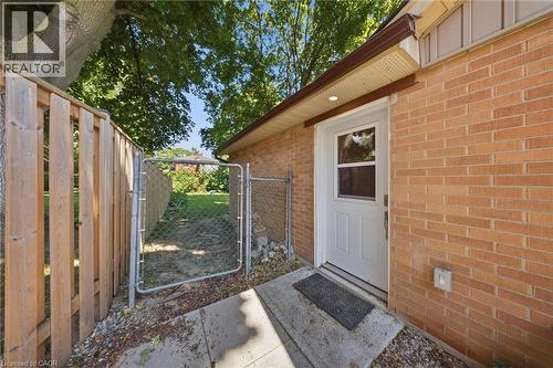 Brick exterior featuring a white entry door with an integrated window, covered by a soffit with recessed lighting - 80 Jackson Avenue, Kitchener, ON - Outdoor With Exterior