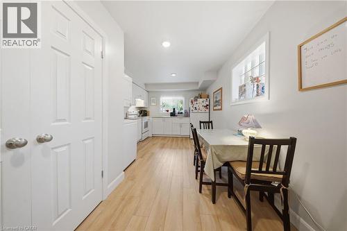 Open-concept kitchen and dining area featuring light wood-finish flooring, white cabinetry, and recessed lighting - 80 Jackson Avenue, Kitchener, ON - Indoor