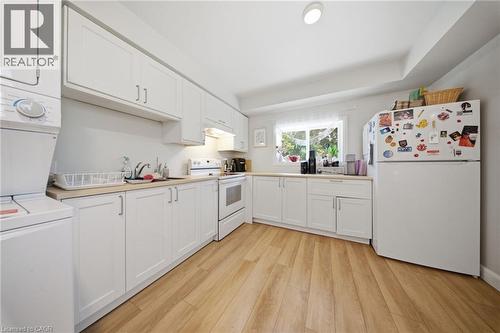 Kitchen featuring white cabinetry and wood-finish flooring - 80 Jackson Avenue, Kitchener, ON - Indoor Photo Showing Laundry Room