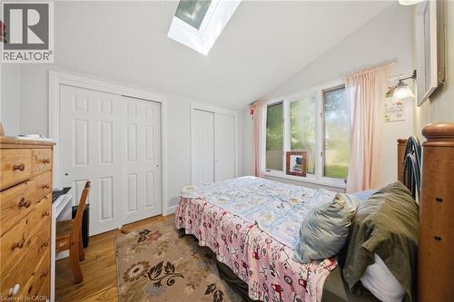 Room featuring a vaulted ceiling with a skylight, wood-finish flooring, and multiple windows - 80 Jackson Avenue, Kitchener, ON - Indoor Photo Showing Bedroom