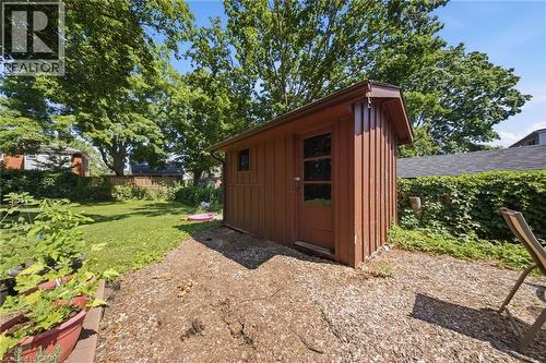 Wood-sided outbuilding with a single paneled door and small window, situated on a ground cover patio - 80 Jackson Avenue, Kitchener, ON - Outdoor