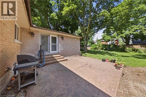 Expansive stamped concrete patio with multiple steps leading to a sliding glass door entry - 80 Jackson Avenue, Kitchener, ON - Outdoor