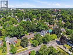 Aerial view of a residential neighborhood with extensive tree canopies, residential streets, and diverse architectural styles - 