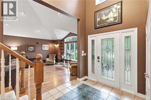 Foyer featuring a decorative glass front door with sidelights, complemented by a tiled entry and wood-finish flooring - 5 Manor Crescent, Grimsby, ON - Indoor Photo Showing Other Room