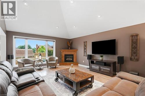 Spacious living area featuring a vaulted ceiling with recessed lighting, wood-finish flooring, and a fireplace with a detailed wood mantel - 5 Manor Crescent, Grimsby, ON - Indoor Photo Showing Living Room With Fireplace