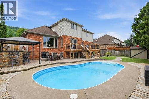 In-ground saltwater pool surrounded by concrete and wood-finish decking - 5 Manor Crescent, Grimsby, ON - Outdoor With In Ground Pool With Deck Patio Veranda With Backyard With Exterior