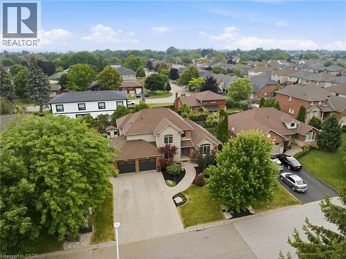 Stone and brick facade residence featuring a two-car garage, paver driveway, and mature landscaping - 5 Manor Crescent, Grimsby, ON - Outdoor With View