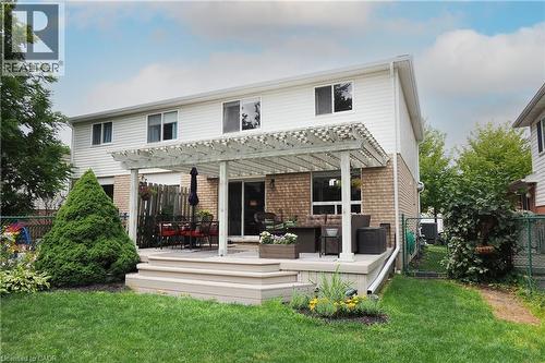 Rear exterior featuring a multi-level deck, white pergola, and brick lower facade - 218 Inverhuron Crescent Unit# A, Waterloo, ON - Outdoor With Deck Patio Veranda