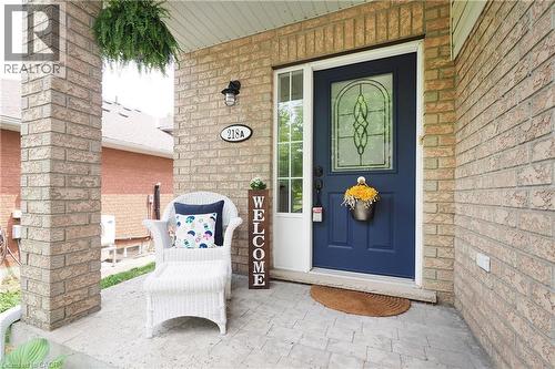 Brick facade entry with a dark blue door featuring a decorative glass insert and white trim - 218 Inverhuron Crescent Unit# A, Waterloo, ON - Outdoor With Deck Patio Veranda With Exterior