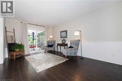 Spacious room featuring dark wood-finish flooring, white walls, and wainscoting - 218 Inverhuron Crescent Unit# A, Waterloo, ON - Indoor Photo Showing Living Room