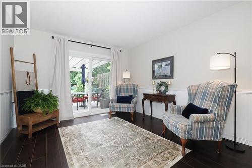 Hardwood-finish flooring throughout, beadboard wainscoting, and white walls - 218 Inverhuron Crescent Unit# A, Waterloo, ON - Indoor Photo Showing Living Room
