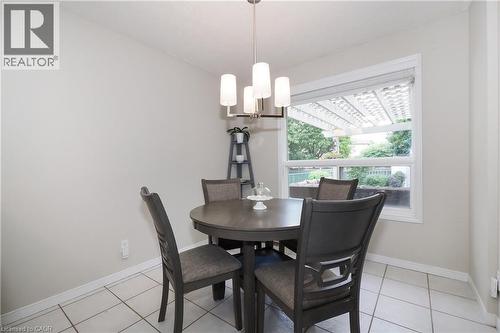 Dining area featuring white ceramic tile flooring and a large window - 218 Inverhuron Crescent Unit# A, Waterloo, ON - Indoor Photo Showing Dining Room