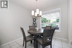 Dining area featuring white ceramic tile flooring and a large window - 
