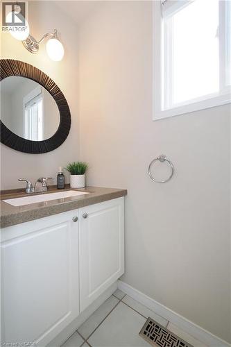 White vanity with a built-in sink, stone-finish countertop, and chrome faucet - 218 Inverhuron Crescent Unit# A, Waterloo, ON - Indoor Photo Showing Bathroom
