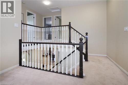 Upper-level landing featuring a staircase with contrasting dark wood handrails and white balusters - 218 Inverhuron Crescent Unit# A, Waterloo, ON - Indoor Photo Showing Other Room