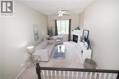 Living area featuring vaulted ceilings, a ceiling fan, and a fireplace with a white mantel - 218 Inverhuron Crescent Unit# A, Waterloo, ON - Indoor With Fireplace