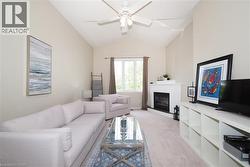 Living space featuring vaulted ceilings, a ceiling fan, and a built-in fireplace with a white mantel - 