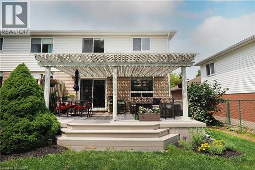 Backyard deck with a white painted pergola, multiple steps, and surrounding green landscaping - 218 Inverhuron Crescent Unit# A, Waterloo, ON - Outdoor With Deck Patio Veranda