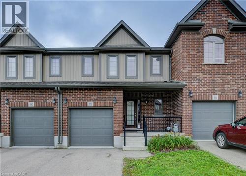 Brick and siding exterior featuring gabled roofs, multiple windows, and individual garage doors - 823 Paris Boulevard, Waterloo, ON - Outdoor With Facade