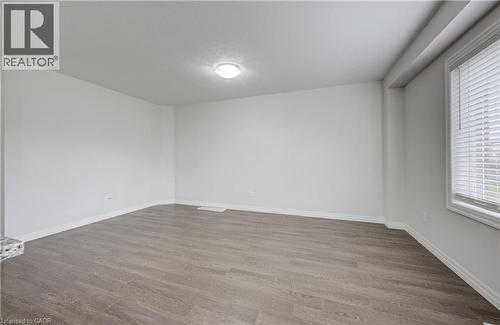 Spacious room featuring light gray wood-finish flooring, white walls, and a recessed ceiling light fixture - 823 Paris Boulevard, Waterloo, ON - Indoor Photo Showing Other Room