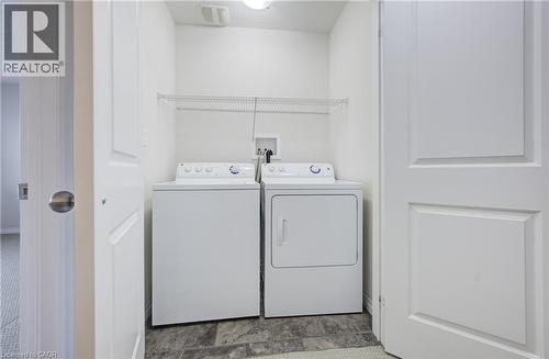 Dedicated laundry area featuring a washer and dryer, wire shelving, and durable flooring - 823 Paris Boulevard, Waterloo, ON - Indoor Photo Showing Laundry Room